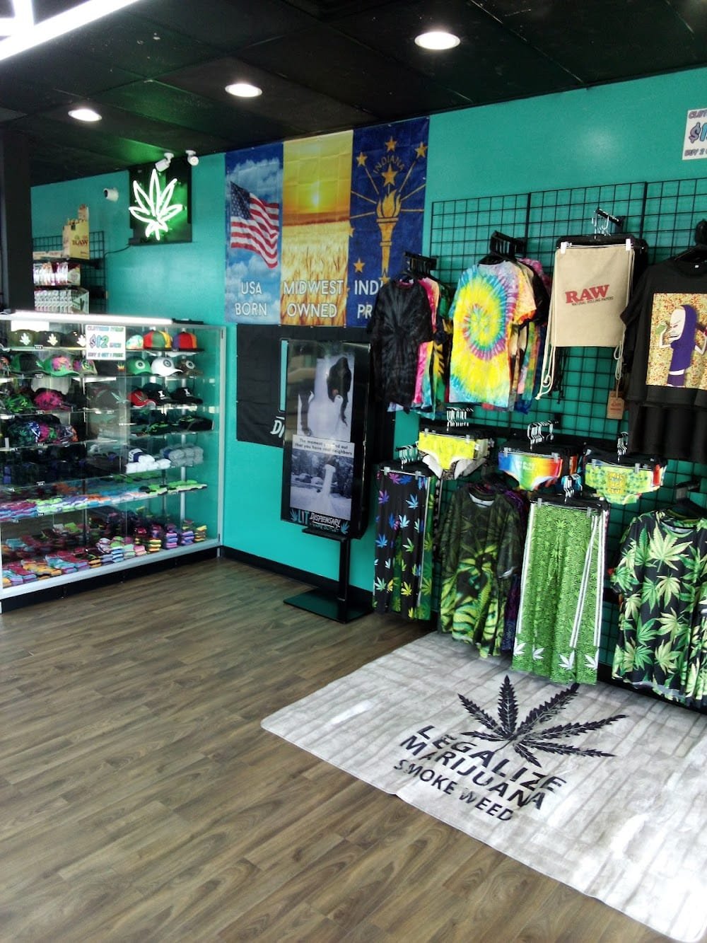 LIT Dispensary store interior showing lifestyle apparel, tie-dye shirts, RAW merchandise, hats, and Indiana Proud banner